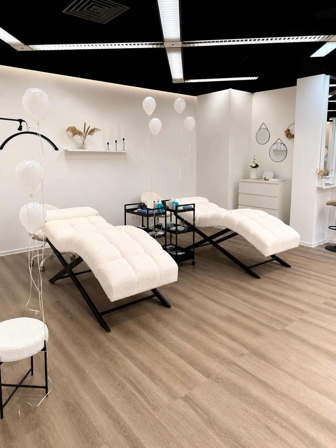 Heller Behandlungsbereich mit Bouclé-Liegen bei Lessa Aesthetics